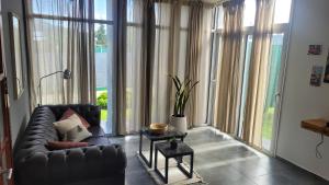 Juana Koslay Sierra Duplex的带沙发和大窗户的客厅