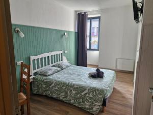 a bedroom with a bed with a teddy bear on it at Eden Auberge in Villefranche-du-Périgord