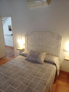 una camera da letto con un letto con due cuscini sopra di Apartamento La Carmela a Utrera