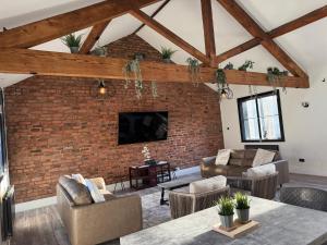 リバプールにあるStylish city centre Penthouseのレンガの壁のオープンリビングルーム