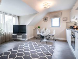 a kitchen and dining room with a table and a tv at Belfast city stylish spacious apartment great location free parking in Belfast