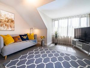 a living room with a couch and a flat screen tv at Belfast city stylish spacious apartment great location free parking in Belfast