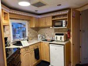 AnderbyにあるStarfish retreat Anderby creekの木製のキャビネットと白い冷蔵庫を備えたキッチン