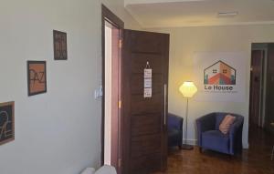 a room with a door and a chair and a lamp at Le house hostel in São Paulo