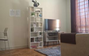 a living room with a tv and white shelves at Le house hostel in São Paulo +30 photos