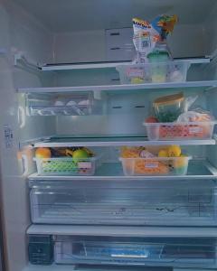 an open refrigerator filled with lots of food at Le house hostel in São Paulo