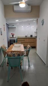 a kitchen with a table and chairs in a room at Apartamento com Suíte em Bertioga Indaiá 150 metros da Praia in Bertioga