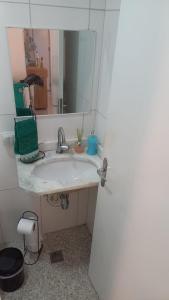 a bathroom with a sink and a mirror at Apartamento com Suíte em Bertioga Indaiá 150 metros da Praia in Bertioga +32 photos