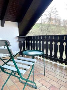 a table and chairs on a balcony with a table and a chair at Odw homes - naturnahe Wohnung im Landhaus in Trösel