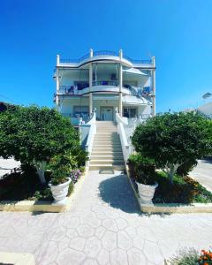 a large building with stairs leading up to it at Apartments Rudi in Orikum