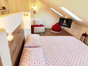 a attic room with two beds and a tv at Le Grenier Apartment in Turin