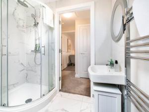 a white bathroom with a shower and a sink at Belfast city stylish spacious apartment great location free parking in Belfast +13 photos