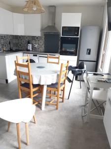 eine Küche und ein Esszimmer mit Tisch und Stühlen in der Unterkunft Ossau T2 5 personnes piscine climatisation 1 chambre draps serviettes inclus parking moustiquaires lave vaisselle lave linge tout confort in Bielle + 24 Fotos
