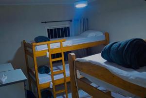 a dorm room with two bunk beds and a desk at Le house hostel in São Paulo