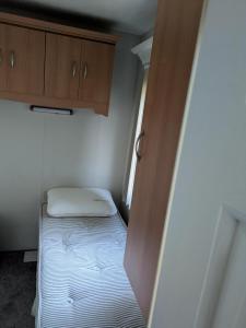 Piccola camera con letto e armadi in legno. di L28 Millfield 4 Berth 3 Bedrooms DG & GCH Familys Only And Lead Person Must Be Over 30 a Ingoldmells