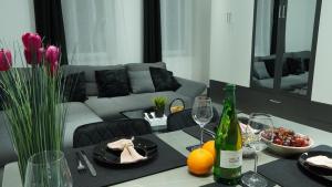 a living room with a table with a bottle of wine at Ferienwohnung - modernes Heim Li-Apartments in Pforzheim