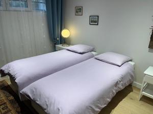 two beds sitting next to each other in a bedroom at A l'orée de la forêt in Saint-Leu-la-Forêt