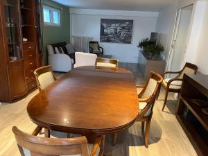 a dining room with a wooden table and chairs at A l'orée de la forêt in Saint-Leu-la-Forêt