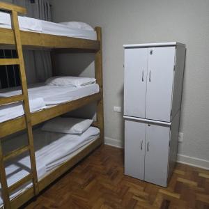 a bunk room with two bunk beds and a refrigerator at Le house hostel in São Paulo