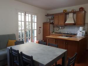 eine Küche mit einem Tisch, Stühlen und einer Theke in der Unterkunft Le Sughere in Procchio