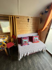 a room with a bed with two pillows and a window at Roulotte en Camargue-Hébergement insolite "LA ROULOTTE DE ROMIE", à 15 minutes d'AIGUES-MORTES in Vauvert