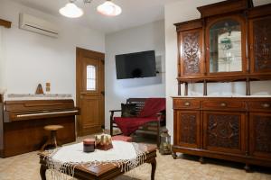 a living room with a piano and a dresser at Villa Tonia in Klaïniánika