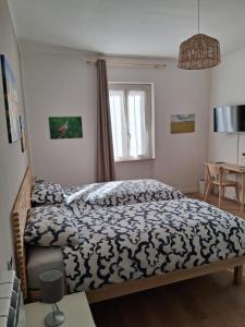 a bedroom with a bed with a blue and white comforter at Che sarà mai in Santa Maria degli Angeli