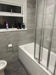 a bathroom with a shower and a tub and a toilet at Room close to City and Hospital in Cardiff