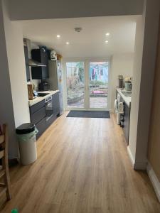 a kitchen with a wooden floor and a large door at Room close to City and Hospital in Cardiff