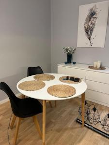 Biały stół w pokoju z 2 krzesłami w obiekcie Apartament Turkusowy w Szczecinie