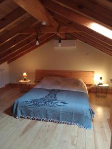 ein Schlafzimmer mit einem Bett in einem Zimmer mit Holzdecken in der Unterkunft Casinha das Estrelas in Cerejeira