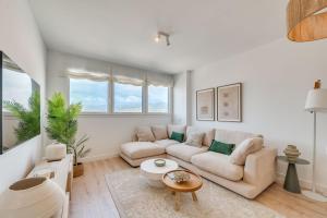 a white living room with a couch and a table at Sky Urban Tower in Málaga