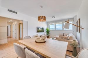 a dining room and living room with a table and chairs at Sky Urban Tower in Málaga