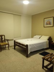 a bedroom with a large bed and a chair at Hotel Libertador in Santa Cruz de la Sierra
