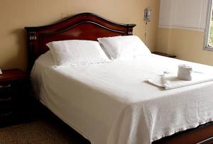 a white bed with two white towels on it at Hotel Libertador in Santa Cruz de la Sierra