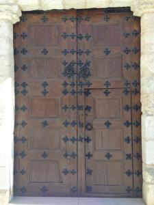 a large wooden door in a stone building at Casa Palacio de Guadix in Guadix