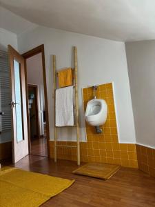 a bathroom with a urinal and a yellow tile wall at O Lar do Canteiro in O Casal Pontevedra +16 photos