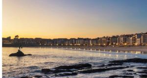 a person standing on a rock in the water at the beach at O Lar do Canteiro in O Casal Pontevedra
