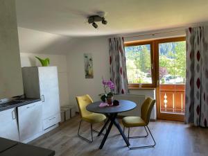 a kitchen with a small table and chairs and a kitchen with a window at Ferienwohnung beim Max in Techendorf