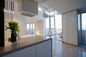 a kitchen with white cabinets and a table at Luxusný Penthouse nad jazerami 230 m2, 2x garáž, WIFI in Senec