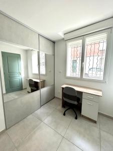una camera con scrivania, due finestre e un tavolo di Joli RDC à 2 pas du centre ville ad Avignone