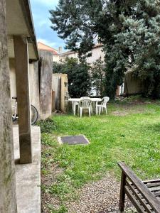 un patio con tavolo e sedie in un cortile di Joli RDC à 2 pas du centre ville ad Avignone