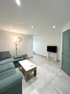 un soggiorno con un divano e una TV di Joli RDC à 2 pas du centre ville ad Avignone