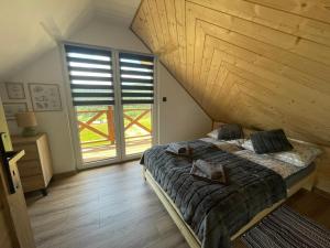 a bedroom with a bed and a large window at Chata Rajski Widok in Baligród