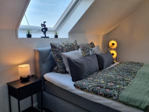 a bedroom with a couch with pillows and a window at Wellnesshaus Dorfblick mit Outdoor-Jacuzzi und Infrarotkabine in Dreis-Brück +20 photos