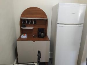 - une petite cuisine avec un comptoir à côté d'un réfrigérateur dans l'établissement Casa no Centro de Tinguá, à Nova Iguaçu