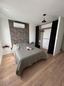 a bedroom with a large bed and a wooden floor at Agréable MAISON familiale - Terrasse - 4 Chambres - 2 SDB - Limoges in Limoges