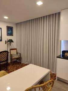 a living room with curtains and a white table at Santa Beatriz Apartment in Machico +2 photos