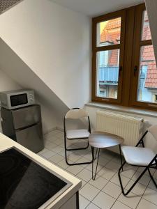 a kitchen with two chairs and a table and a microwave at Linda Ninh Apartment 6 Altstadt in Dresden