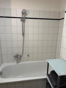 a bath tub with a shower in a bathroom at Linda Ninh Apartment 6 Altstadt in Dresden